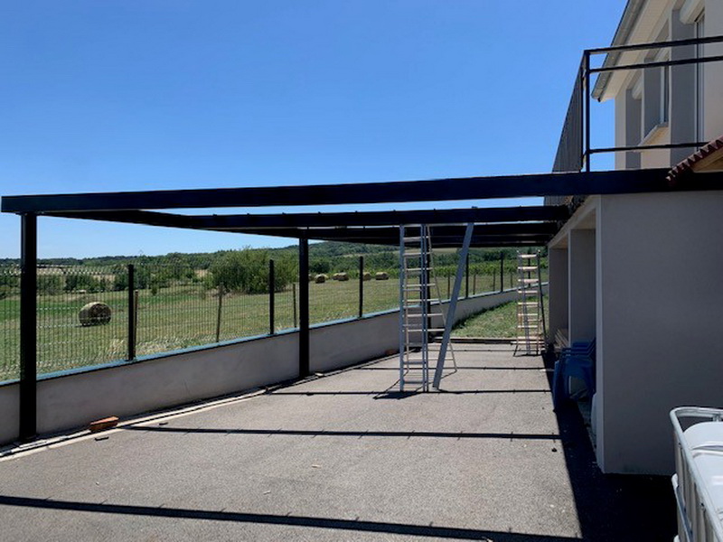 Les propriétaires d'une maison ont fait appel au groupe Pallay pour agrandir leur balcon et créer un car-port sur mesure sous l'extension.